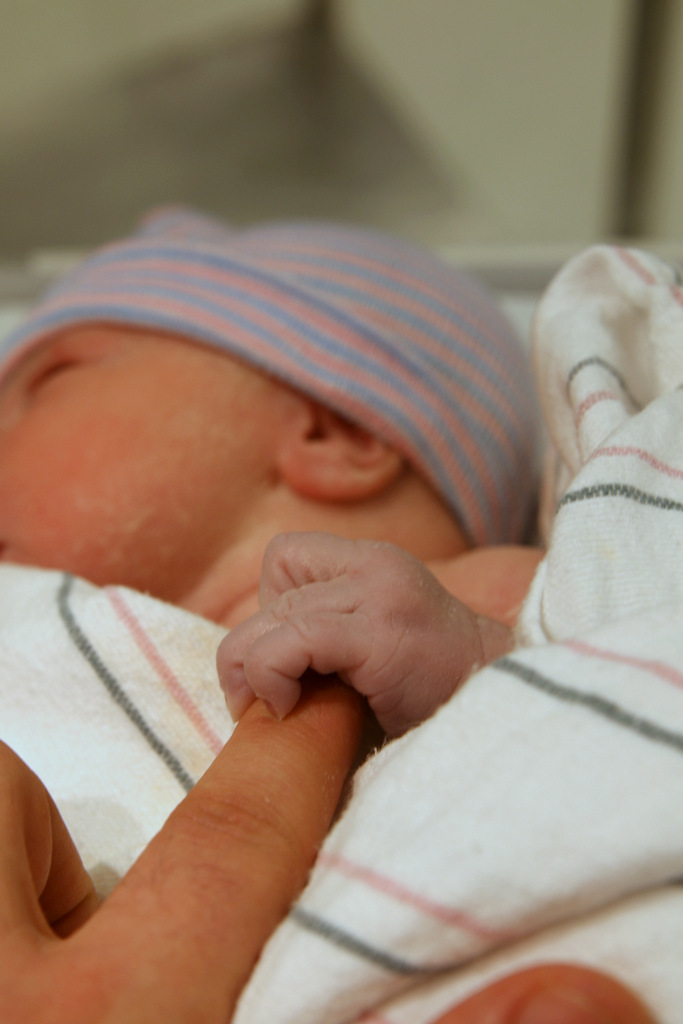 Baby hand grabbing an adult finger